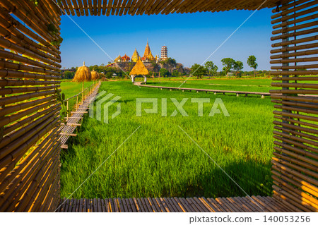 Landscape of Wat Tham Sua Temple (Tiger Cave Temple) with Jasmine rice fields and bamboo frame at Kanchanaburi Province, Thailand. Is an important landmark that everyone must visit Landscape of Wat Tham Sua Temple (Tiger Cave Temple) with Jasmine rice fields and bamboo frame at Kanchanaburi Province, Thailand. Is an important landmark that everyone must visit 140053256