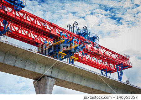 Closeup of high-elevation railway construction crane by modern technology with cloud sky background Closeup of high-elevation railway construction crane by modern technology with cloud sky background 140053357