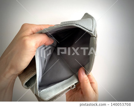 Close-up of a woman's hands as she opens an empty wallet. Close-up of a woman's hands as she opens an empty wallet. 140053708