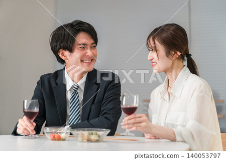 一對夫婦在傍晚的餐桌旁享用葡萄酒。 140053797