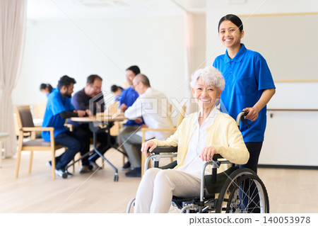 Senior citizen in a wheelchair and foreign caregiver at a nursing home Senior citizen in a wheelchair and foreign caregiver at a nursing home 140053978