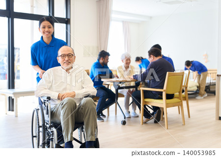 Senior citizen in a wheelchair and foreign caregiver at a nursing home 140053985