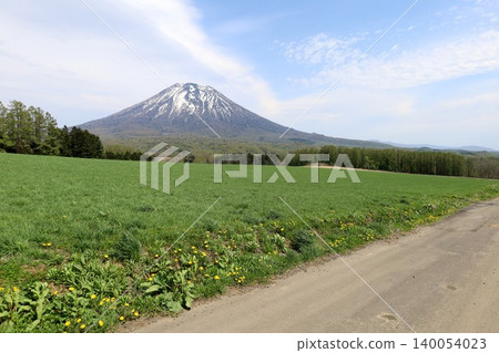 May in Hokkaido: Niseko, Kutchan, Ezo Fuji, Mount Yotei, Mount Yotei with lingering snow, the majestic mountain of Hokkaido, shining brightly against the blue sky. May in Hokkaido: Niseko, Kutchan, Ezo Fuji, Mount Yotei, Mount Yotei with lingering snow, the majestic mountain of Hokkaido, shining brightly against the blue sky. 140054023