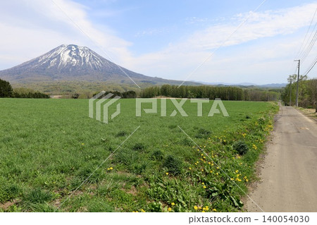 May in Hokkaido: Niseko, Kutchan, Ezo Fuji, Mount Yotei, Mount Yotei with lingering snow, the majestic mountain of Hokkaido, shining brightly against the blue sky. May in Hokkaido: Niseko, Kutchan, Ezo Fuji, Mount Yotei, Mount Yotei with lingering snow, the majestic mountain of Hokkaido, shining brightly against the blue sky. 140054030