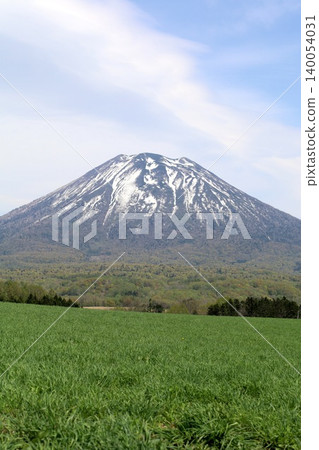 May in Hokkaido: Niseko, Kutchan, Ezo Fuji, Mount Yotei, Mount Yotei with lingering snow, the majestic mountain of Hokkaido, shining brightly against the blue sky. May in Hokkaido: Niseko, Kutchan, Ezo Fuji, Mount Yotei, Mount Yotei with lingering snow, the majestic mountain of Hokkaido, shining brightly against the blue sky. 140054031