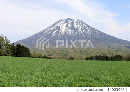 May in Hokkaido: Niseko, Kutchan, Ezo Fuji, Mount Yotei, Mount Yotei with lingering snow, the majestic mountain of Hokkaido, shining brightly against the blue sky. May in Hokkaido: Niseko, Kutchan, Ezo Fuji, Mount Yotei, Mount Yotei with lingering snow, the majestic mountain of Hokkaido, shining brightly against the blue sky. 140054034