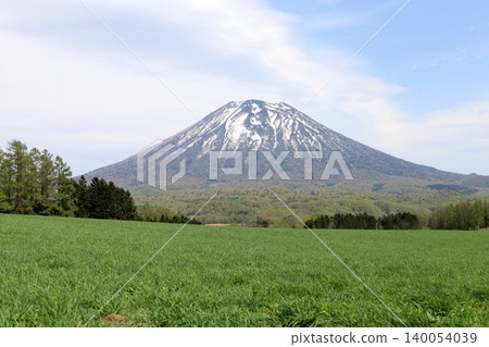 May in Hokkaido: Niseko, Kutchan, Ezo Fuji, Mount Yotei, Mount Yotei with lingering snow, the majestic mountain of Hokkaido, shining brightly against the blue sky. May in Hokkaido: Niseko, Kutchan, Ezo Fuji, Mount Yotei, Mount Yotei with lingering snow, the majestic mountain of Hokkaido, shining brightly against the blue sky. 140054039