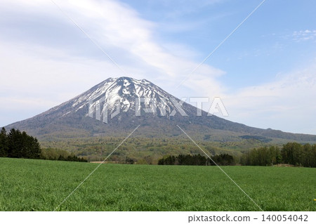 May in Hokkaido: Niseko, Kutchan, Ezo Fuji, Mount Yotei, Mount Yotei with lingering snow, the majestic mountain of Hokkaido, shining brightly against the blue sky. May in Hokkaido: Niseko, Kutchan, Ezo Fuji, Mount Yotei, Mount Yotei with lingering snow, the majestic mountain of Hokkaido, shining brightly against the blue sky. 140054042