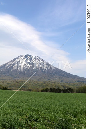 May in Hokkaido: Niseko, Kutchan, Ezo Fuji, Mount Yotei, Mount Yotei with lingering snow, the majestic mountain of Hokkaido, shining brightly against the blue sky. May in Hokkaido: Niseko, Kutchan, Ezo Fuji, Mount Yotei, Mount Yotei with lingering snow, the majestic mountain of Hokkaido, shining brightly against the blue sky. 140054043