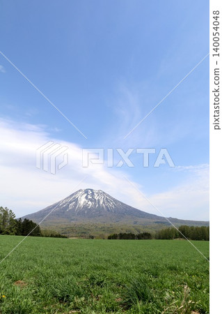 May in Hokkaido: Niseko, Kutchan, Ezo Fuji, Mount Yotei, Mount Yotei with lingering snow, the majestic mountain of Hokkaido, shining brightly against the blue sky. 140054048