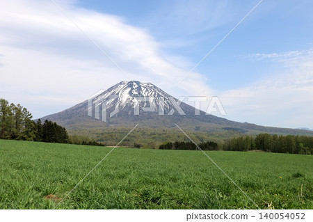 May in Hokkaido: Niseko, Kutchan, Ezo Fuji, Mount Yotei, Mount Yotei with lingering snow, the majestic mountain of Hokkaido, shining brightly against the blue sky. May in Hokkaido: Niseko, Kutchan, Ezo Fuji, Mount Yotei, Mount Yotei with lingering snow, the majestic mountain of Hokkaido, shining brightly against the blue sky. 140054052