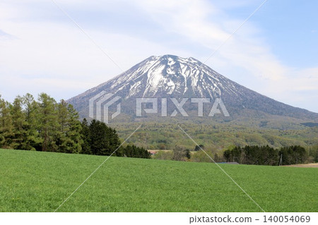 May in Hokkaido: Niseko, Kutchan, Ezo Fuji, Mount Yotei, Mount Yotei with lingering snow, the majestic mountain of Hokkaido, shining brightly against the blue sky. May in Hokkaido: Niseko, Kutchan, Ezo Fuji, Mount Yotei, Mount Yotei with lingering snow, the majestic mountain of Hokkaido, shining brightly against the blue sky. 140054069