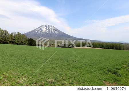 May in Hokkaido: Niseko, Kutchan, Ezo Fuji, Mount Yotei, Mount Yotei with lingering snow, the majestic mountain of Hokkaido, shining brightly against the blue sky. May in Hokkaido: Niseko, Kutchan, Ezo Fuji, Mount Yotei, Mount Yotei with lingering snow, the majestic mountain of Hokkaido, shining brightly against the blue sky. 140054074