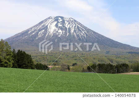 May in Hokkaido: Niseko, Kutchan, Ezo Fuji, Mount Yotei, Mount Yotei with lingering snow, the majestic mountain of Hokkaido, shining brightly against the blue sky. May in Hokkaido: Niseko, Kutchan, Ezo Fuji, Mount Yotei, Mount Yotei with lingering snow, the majestic mountain of Hokkaido, shining brightly against the blue sky. 140054078