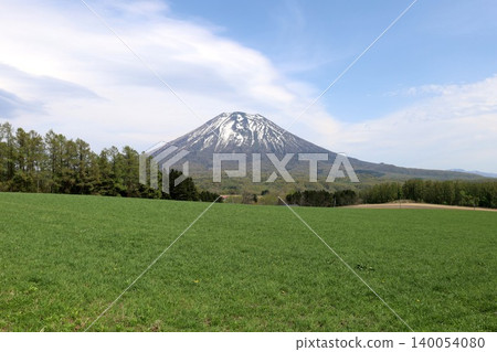 May in Hokkaido: Niseko, Kutchan, Ezo Fuji, Mount Yotei, Mount Yotei with lingering snow, the majestic mountain of Hokkaido, shining brightly against the blue sky. May in Hokkaido: Niseko, Kutchan, Ezo Fuji, Mount Yotei, Mount Yotei with lingering snow, the majestic mountain of Hokkaido, shining brightly against the blue sky. 140054080