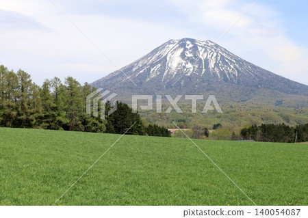 May in Hokkaido: Niseko, Kutchan, Ezo Fuji, Mount Yotei, Mount Yotei with lingering snow, the majestic mountain of Hokkaido, shining brightly against the blue sky. May in Hokkaido: Niseko, Kutchan, Ezo Fuji, Mount Yotei, Mount Yotei with lingering snow, the majestic mountain of Hokkaido, shining brightly against the blue sky. 140054087