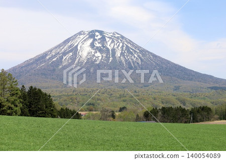 May in Hokkaido: Niseko, Kutchan, Ezo Fuji, Mount Yotei, Mount Yotei with lingering snow, the majestic mountain of Hokkaido, shining brightly against the blue sky. May in Hokkaido: Niseko, Kutchan, Ezo Fuji, Mount Yotei, Mount Yotei with lingering snow, the majestic mountain of Hokkaido, shining brightly against the blue sky. 140054089