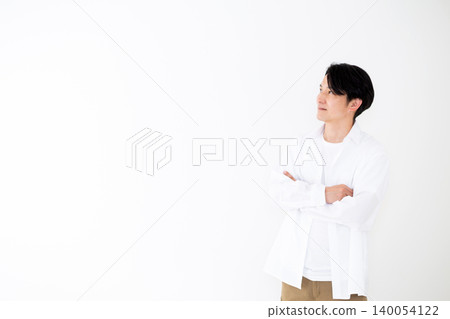 一位身穿白襯衫的年輕中年男子，在白色背景前拍攝的肖像照。 140054122