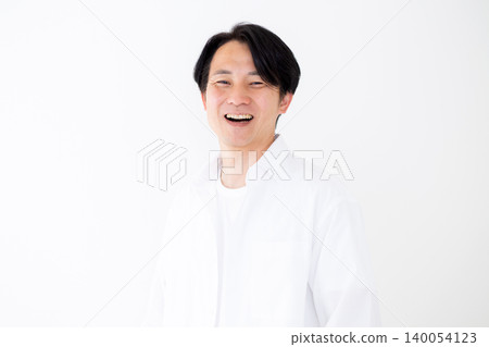 一位身穿白襯衫的年輕中年男子，在白色背景前拍攝的肖像照。 140054123
