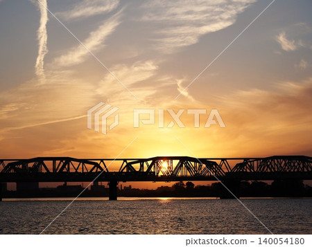 The silhouette of the Arakawa Railway Bridge against an orange sunset. The silhouette of the Arakawa Railway Bridge against an orange sunset. 140054180
