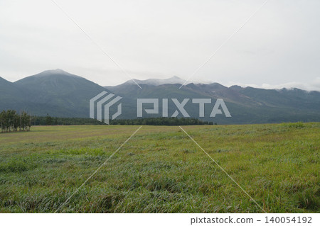 夏末時節,北海道的十勝山脈籠罩在雲霧之中,綠色的草原和連綿的山脈構成了一幅九月初秋陰沉的景象。 夏末時節,北海道的十勝山脈籠罩在雲霧之中,綠色的草原和連綿的山脈構成了一幅九月初秋陰沉的景象。 140054192