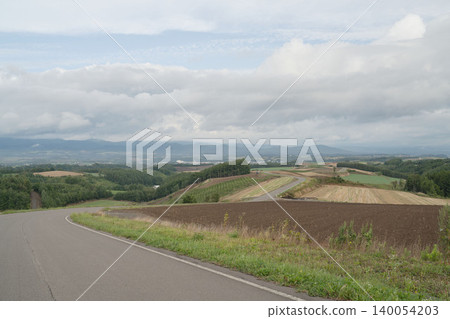 北海道美瑛的風景優美的公路和起伏的山丘;九月初秋的鄉村景色;以及上富良野的全景。 北海道美瑛的風景優美的公路和起伏的山丘;九月初秋的鄉村景色;以及上富良野的全景。 140054203