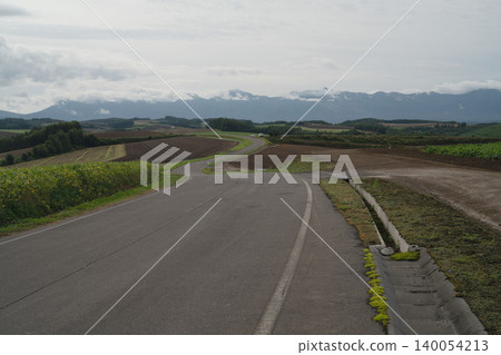 北海道美瑛的山丘和十勝山脈籠罩在雲海之中,呈現出一幅九月初秋陰雲密布的鄉村景色。 北海道美瑛的山丘和十勝山脈籠罩在雲海之中,呈現出一幅九月初秋陰雲密布的鄉村景色。 140054213