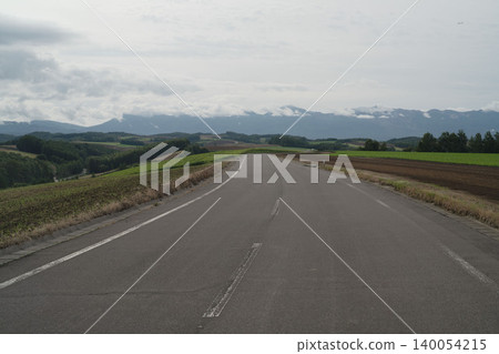 The wide driving roads of Biei in Hokkaido, the Tokachi Mountain Range, and the early autumn fields in September, offer a panoramic view with a sense of openness. The wide driving roads of Biei in Hokkaido, the Tokachi Mountain Range, and the early autumn fields in September, offer a panoramic view with a sense of openness. 140054215