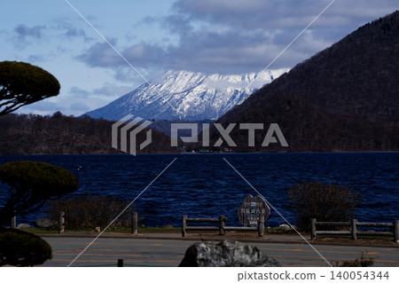 從湖邊可以遠眺北海道洞爺湖和白雪皚皚的羊蹄山，松林藍天交相輝映，景色壯麗。這裡是四月北海道南部的熱門旅遊景點。 140054344