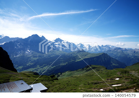 A panoramic view of the Swiss Alps and cirrus clouds, an aerial view of the Grindelwald Valley, and the stunning scenery of Switzerland in mid-August. 140054579