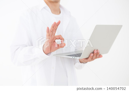一位中年男子手持筆記型電腦,以圓形姿勢站在白色背景前,拍攝了一張肖像照。 一位中年男子手持筆記型電腦,以圓形姿勢站在白色背景前,拍攝了一張肖像照。 140054702