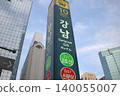 A street scene at Gangnam Station in Seoul, South Korea, set against the clear blue sky of early summer. 140055007