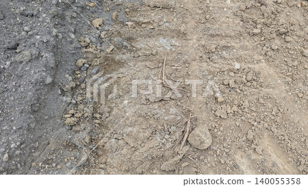 Top view shows a dry soil ground surface texture with stones, small pebbles. Light brown dirt road field offers an organic natural backdrop layout, perfect for agriculture or construction theme. Top view shows a dry soil ground surface texture with stones, small pebbles. Light brown dirt road field offers an organic natural backdrop layout, perfect for agriculture or construction theme. 140055358