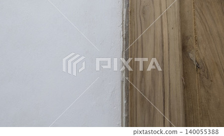 Natural wood grain texture sits adjacent to a smooth white wall surface. Organic brown lines, knots appear on the timber plank. This minimalist background suits interior design, construction, Natural wood grain texture sits adjacent to a smooth white wall surface. Organic brown lines, knots appear on the timber plank. This minimalist background suits interior design, construction, 140055388