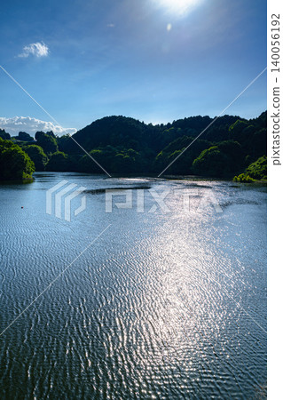 Early summer at Nunome Dam: A beautiful path of light reflected on the full surface of the lake. Early summer at Nunome Dam: A beautiful path of light reflected on the full surface of the lake. 140056192