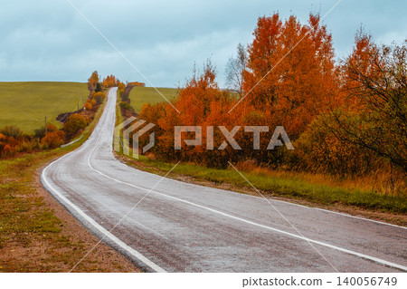 Scenic autumn road winding through colorful trees Scenic autumn road winding through colorful trees 140056749