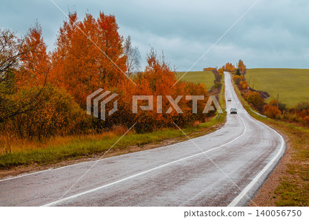 Scenic autumn road winding through colorful trees Scenic autumn road winding through colorful trees 140056750