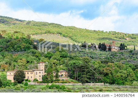 Stunning view of rolling hills with olive groves and historic buildings in Tuscany, Italy 140056764