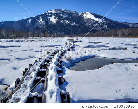 A precious and breathtaking landscape photograph of snow-covered Mt. Shibutsu and frozen ponds viewed from Oze Marsh in early winter, November. 140056956