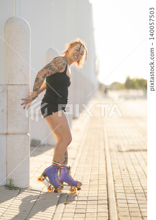 Tattooed woman enjoying urban roller skating outdoors Tattooed woman enjoying urban roller skating outdoors 140057503