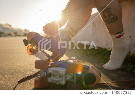 Person lacing roller skates for an outdoor skate Person lacing roller skates for an outdoor skate 140057552