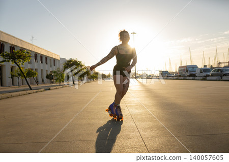 Woman roller skating at sunset feeling freedom and joy Woman roller skating at sunset feeling freedom and joy 140057605