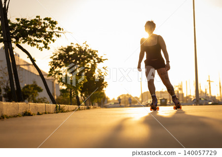 Woman enjoying roller skating during golden hour sunset Woman enjoying roller skating during golden hour sunset 140057729