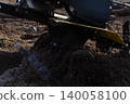 Walk-behind tractor attachment cultivating rich garden soil, preparing the ground for planting, ensuring optimal conditions for growing vegetables and crops in agriculture. 140058100