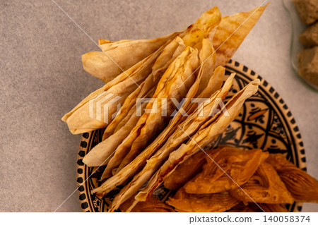 Saudi Arabia food Mutabbaq - thin triangular envelopes of dough with filling fried in a pan. Flatbread is a traditional Arabic food. Saudi Arabia food Mutabbaq - thin triangular envelopes of dough with filling fried in a pan. Flatbread is a traditional Arabic food. 140058374