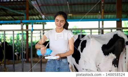 Dairy worker applying milk quality testing before milking process in farm Dairy worker applying milk quality testing before milking process in farm 140058524