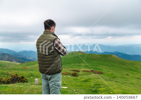Man standing on mountain meadow under storm clouds in Catalan Pyrenees Man standing on mountain meadow under storm clouds in Catalan Pyrenees 140058667