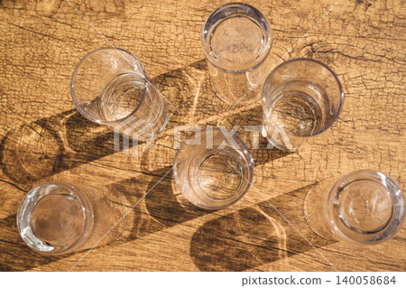 Transparent Glasses on a Wooden Background Transparent Glasses on a Wooden Background 140058684