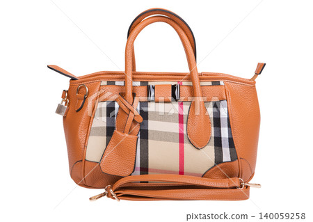 Silver metallic leather handbag with brown tassels isolated on white background. Front view of a soft female tote bag with decorative side zippers. Silver metallic leather handbag with brown tassels isolated on white background. Front view of a soft female tote bag with decorative side zippers. 140059258