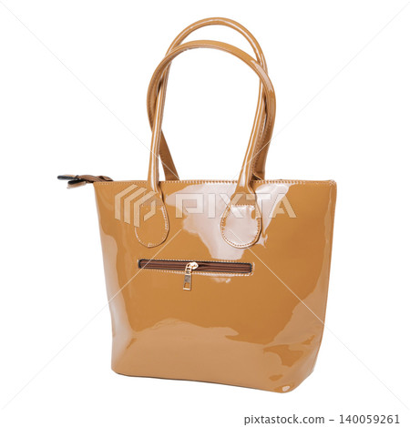 Light brown leather tote bag with front zipper pocket isolated on white background. Side view of a classic female shopper handbag with top handles. Light brown leather tote bag with front zipper pocket isolated on white background. Side view of a classic female shopper handbag with top handles. 140059261